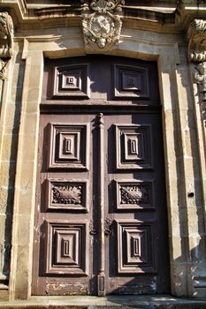 Old wooden carved brown door in Porto, Portugal
