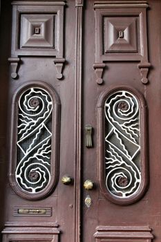 Old wooden brown door with wrought iron details in Porto, Portugal