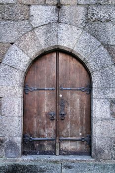 Old wooden brown door with wrought iron details in Porto, Portugal