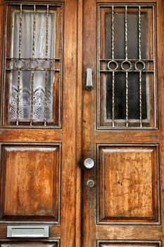 Old wooden door with curtain and wrought iron details in Porto, Portugal