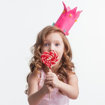 Beautiful little candy princess girl in crown with big pink heart lollipop