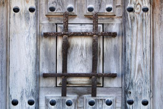 Old wooden brown door with wrought iron details in Porto, Portugal