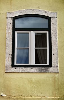 Old colorful and bright typical facade in Lisbon with beautiful vintage wooden window