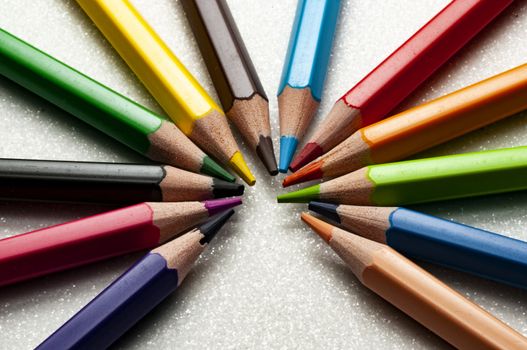An open wheel of colored pencils in white background