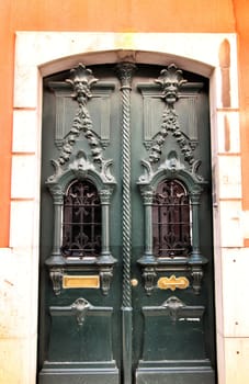 Old and colorful carved wood door with iron details in Lisbon, Portugal