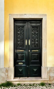 Old and colorful wooden door with iron details in Lisbon, Portugal