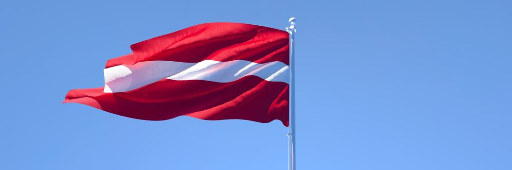 3D rendering of the national flag of Latvia waving in the wind against a blue sky