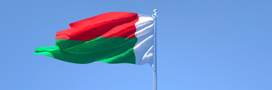 3D rendering of the national flag of Madagascar waving in the wind against a blue sky