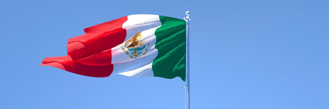 3D rendering of the national flag of Mexico waving in the wind against a blue sky