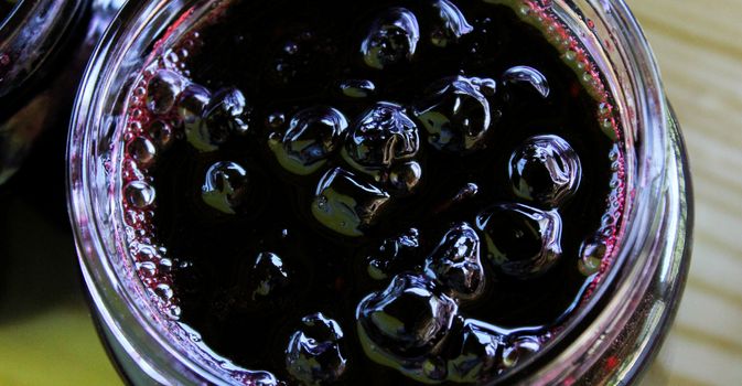 Banner of chokeberry jam in a glass jar. Sweet from aronia. Zavidovici, Bosnia and Herzegovina.