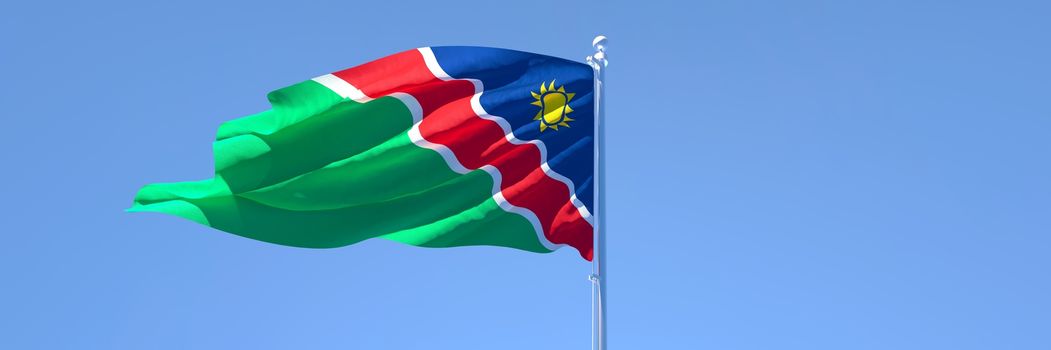 3D rendering of the national flag of Namibia waving in the wind against a blue sky