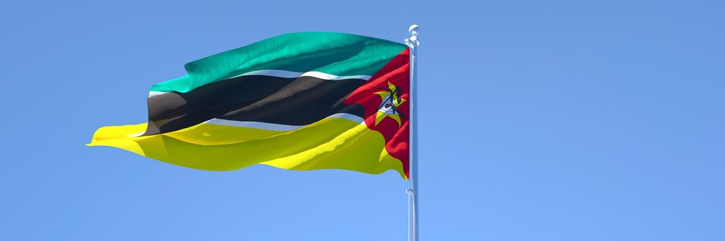 3D rendering of the national flag of Mozambique waving in the wind against a blue sky