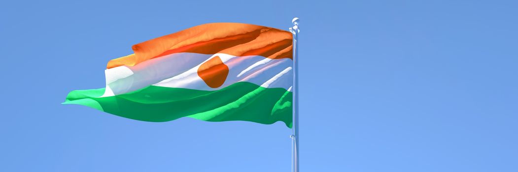 3D rendering of the national flag of Niger waving in the wind against a blue sky