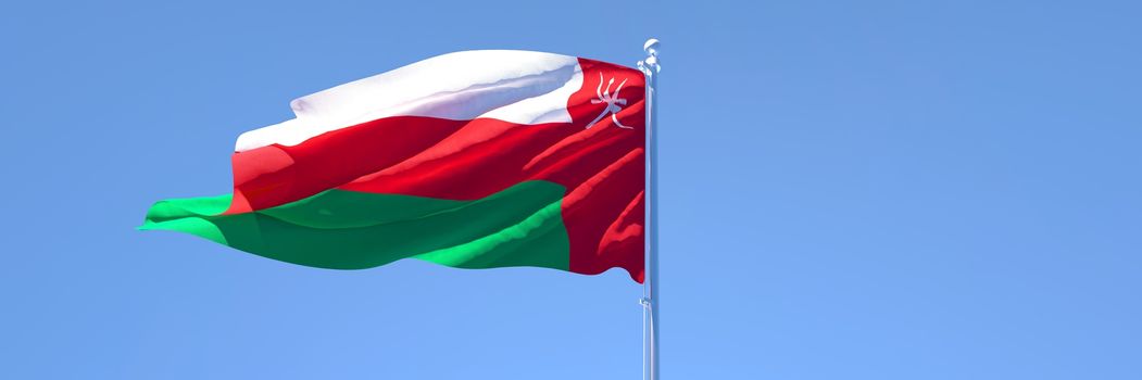 3D rendering of the national flag of Oman waving in the wind against a blue sky