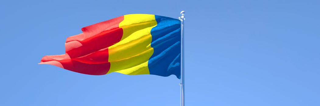 3D rendering of the national flag of Romania waving in the wind against a blue sky