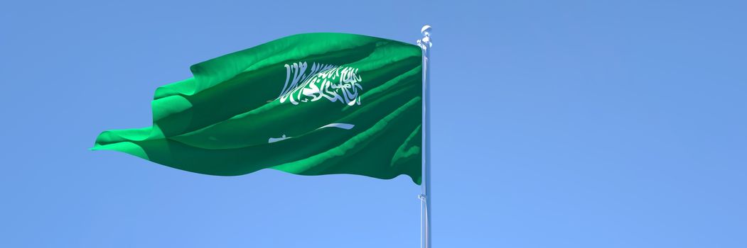 3D rendering of the national flag of Saudi Arabia waving in the wind against a blue sky