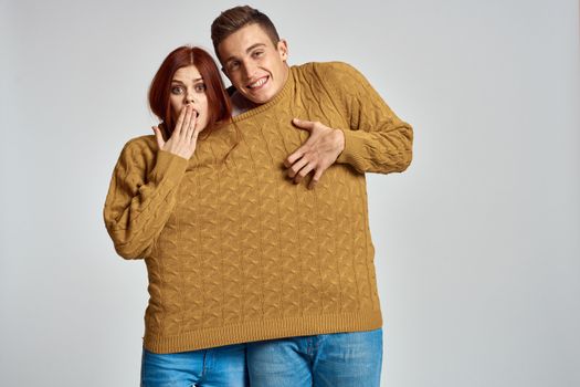 couple in yellow sweater posing against light background cropped view. High quality photo