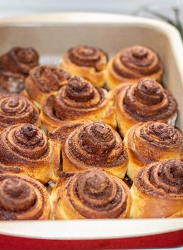 Delicious round cinnamon rolls on a baking sheet after the oven. I cook buns at home in the oven.