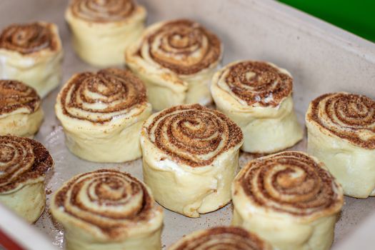 Rolled cinnamon dough on a baking sheet in the oven. Cooking buns.