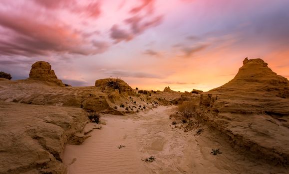 Sunset in the sandy desert with wind and rain eroded landforms outback Australia