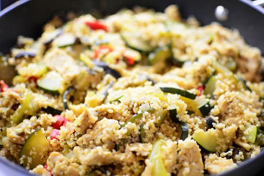 Closeup of roasted vegetables with cous cous in the pan.