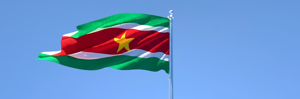 3D rendering of the national flag of Suriname waving in the wind against a blue sky