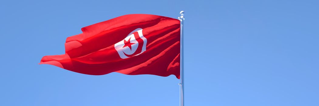 3D rendering of the national flag of Tunisia waving in the wind against a blue sky