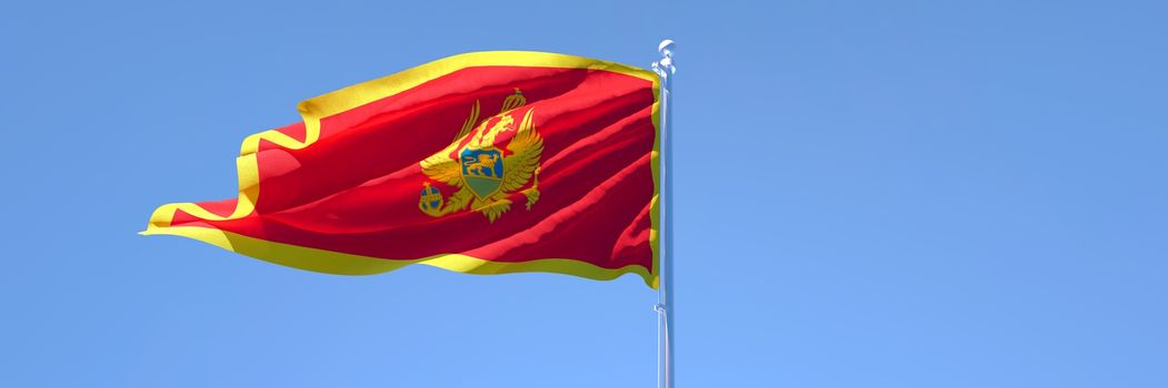 3D rendering of the national flag of Montenegro waving in the wind against a blue sky