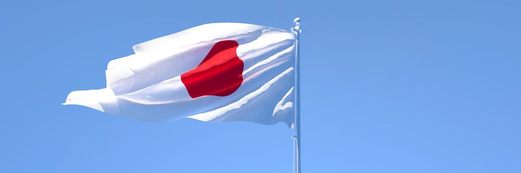 3D rendering of the national flag of Japan waving in the wind against a blue sky