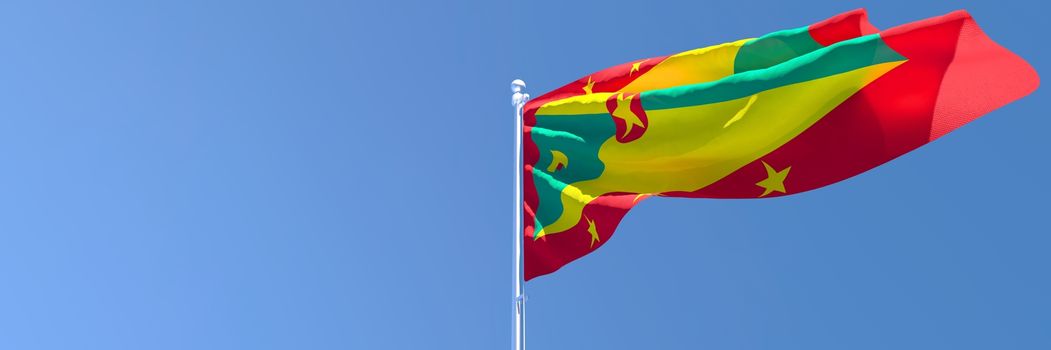3D rendering of the national flag of Grenada waving in the wind against a blue sky