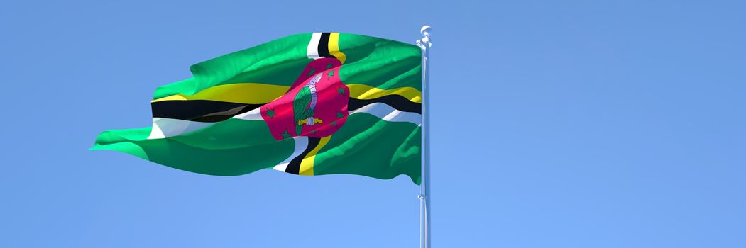 3D rendering of the national flag of Dominica waving in the wind against a blue sky