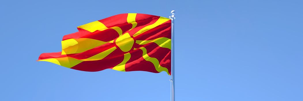 3D rendering of the national flag of Macedonia waving in the wind against a blue sky