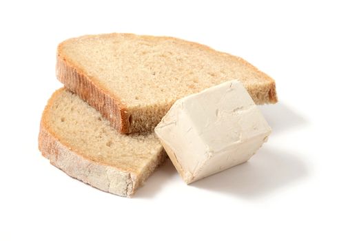 Fresh yeast block and two slices of bread over white background.