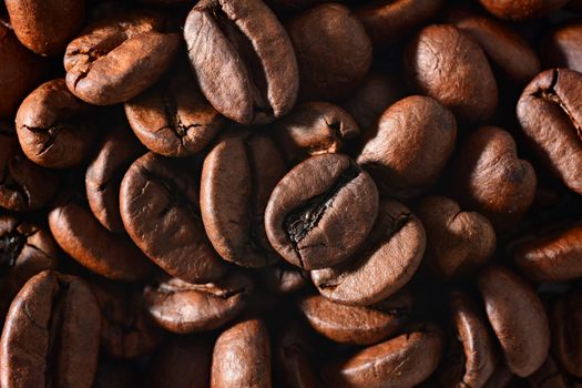 Roasted coffee beans full frame background. Macro shot of coffee beans with visible texture.