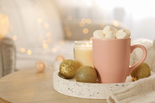 Winter concept with cup of coffee with marshmallow and blurred lights