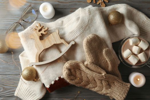 Winter concept with coffee with marshmallow, sweater and candles on wooden background