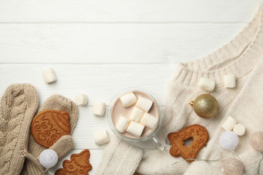 Winter concept with sweater, coffee with marshmallow and cookies on wooden background