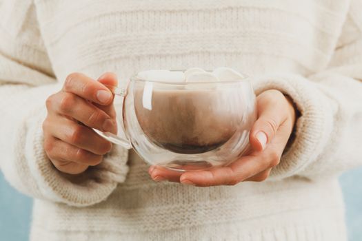 Woman hold cup of coffee with marshmallows, front view