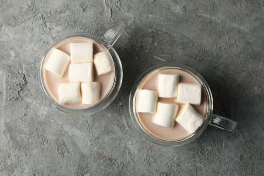 Cups of coffee with marshmallows on gray background