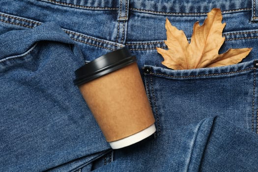 Jeans with leaf in pocket and paper cup, space for text