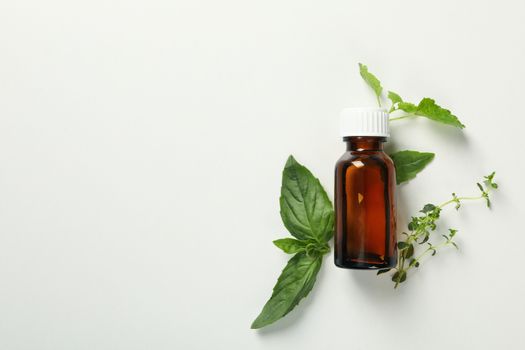 Medical bottle and herbs on white background, space for text