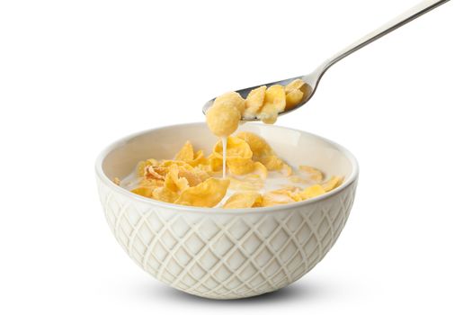 Spoon and bowl of muesli with milk isolated on white background