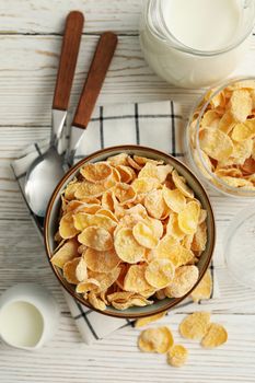 Concept of breakfast with muesli and milk on white wooden table