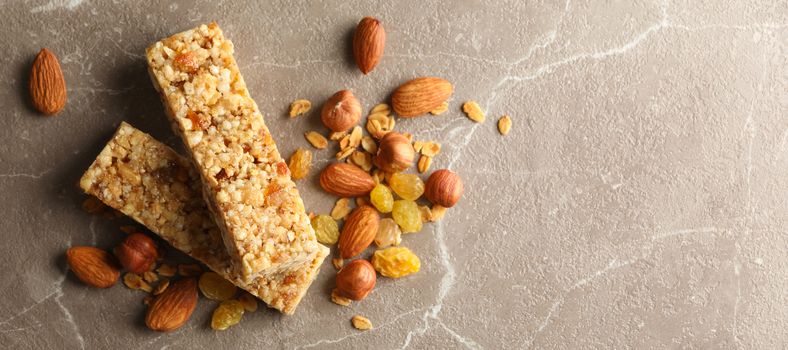 Tasty granola bars on gray background, top view