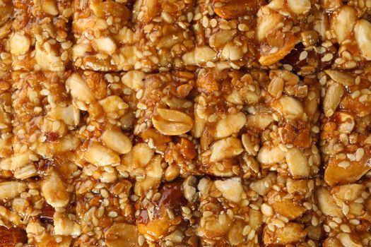 Tasty peanut brittle on whole background, close up