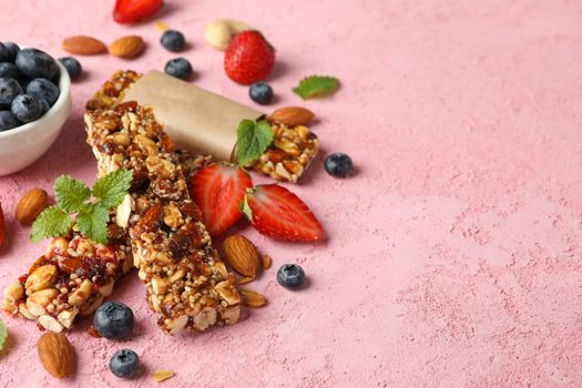 Granola bars and bowl with blueberry on pink background, space for text