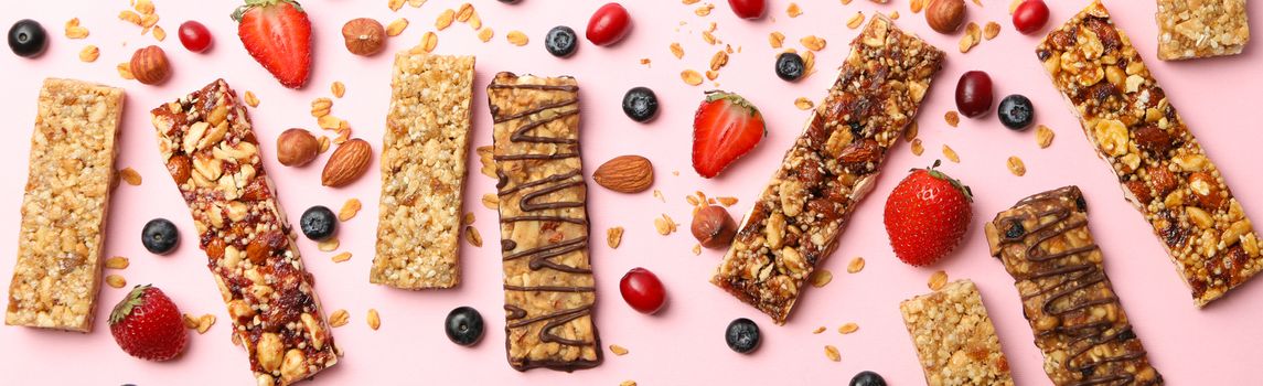 Tasty granola bars on pink background, top view