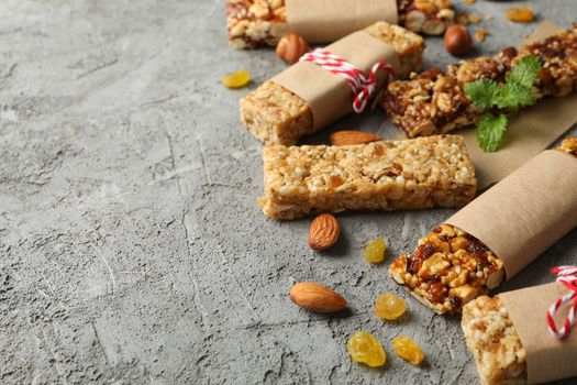 Tasty granola bars on gray background, space for text