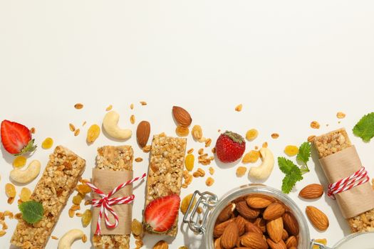 Granola bars, strawberry and almond on white background, top view