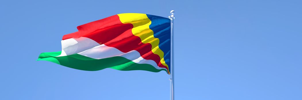 3D rendering of the national flag of Seychelles waving in the wind against a blue sky